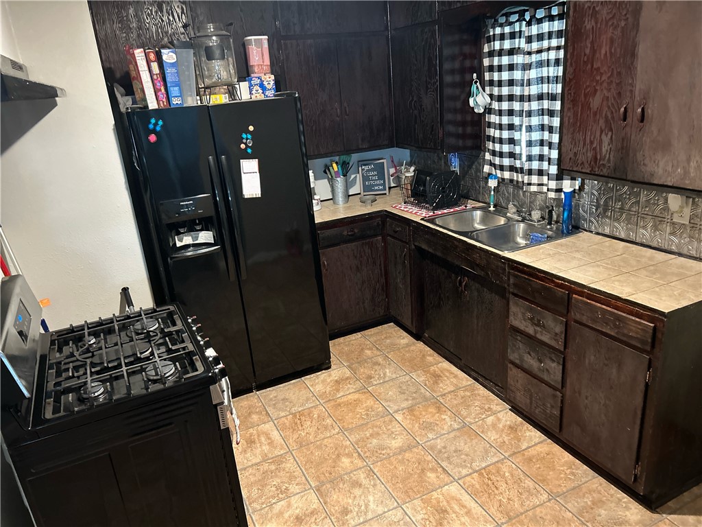 202 Coryell City Road Gatesville, TX 76528 - Photo 8 of 15 a kitchen with stainless steel appliances kitchen island granite countertop a refrigerator and a stove