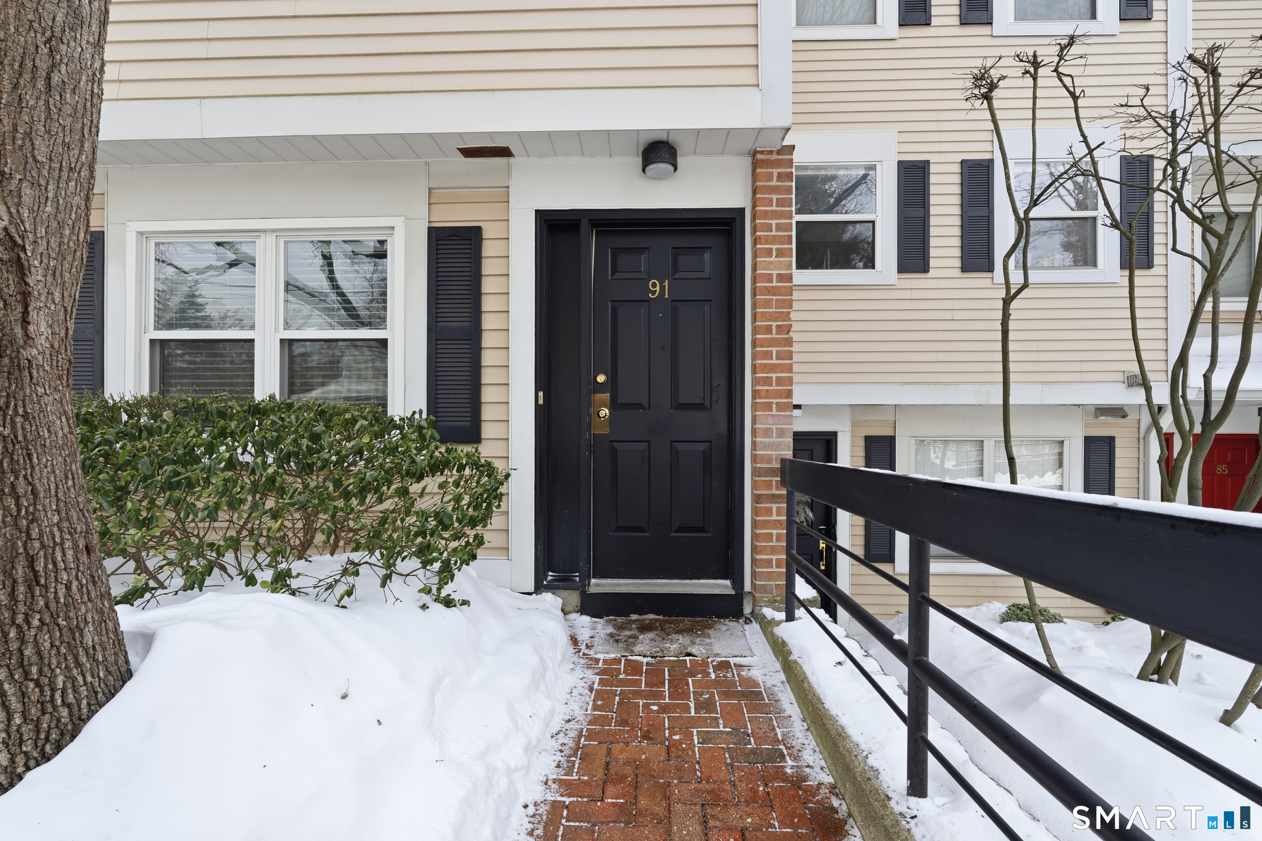 91 Highland Road, Unit 91 Stamford, CT 06901 - Photo 1 of 15 a front view of a house with a glass door