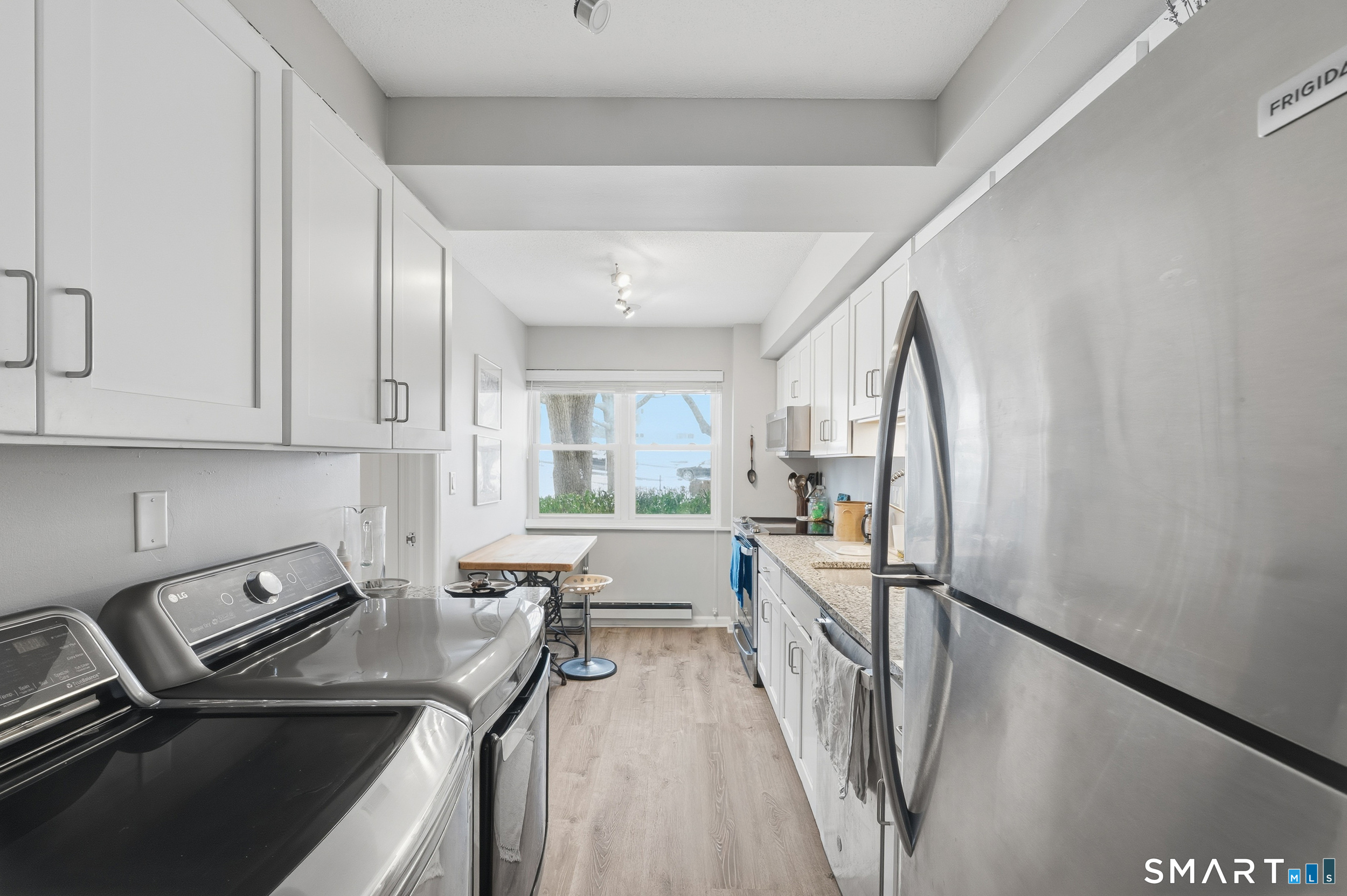 91 Highland Road, Unit 91 Stamford, CT 06901 - Photo 3 of 15 a view of a kitchen with fridge and wooden floor