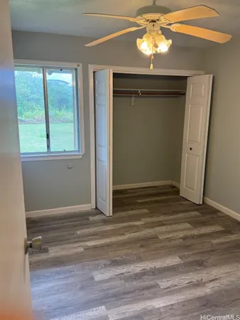 a view of empty room with window and wooden floor