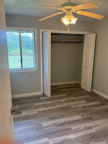 a view of empty room with window and wooden floor