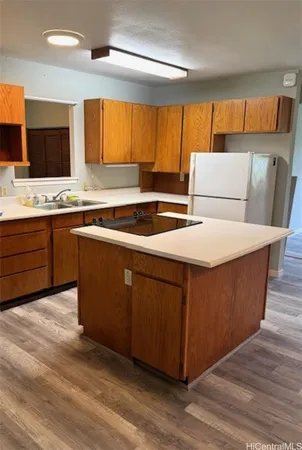 a kitchen with stainless steel appliances kitchen island granite countertop a stove a sink and a refrigerator