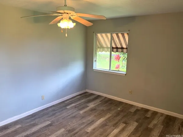an empty room with a window and a fan