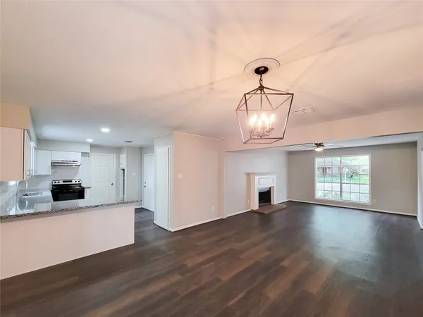 a view of a kitchen with an empty space and wooden floor