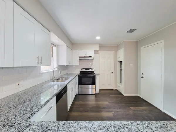 a kitchen with granite countertop a stove and a sink