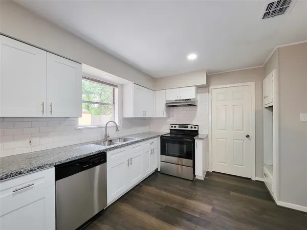 a kitchen with stainless steel appliances granite countertop a sink and a stove