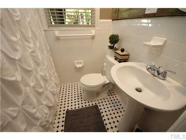 2006 Bernard Street Raleigh, NC 27608 - Photo 16 of 25 The guest bath downstairs comes complete with a tub shower, pedestal sink, ceramic tile floors and walls as well as fresh paint. Bathroom