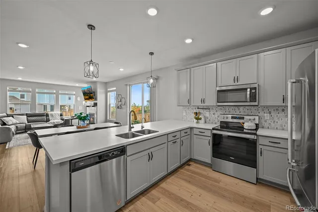 a kitchen with stainless steel appliances granite countertop a sink stove and refrigerator
