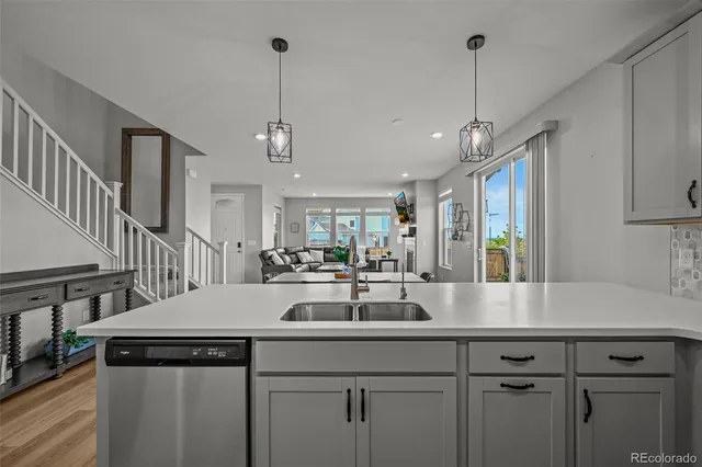 a kitchen with stainless steel appliances granite countertop a sink a stove and a wooden floors