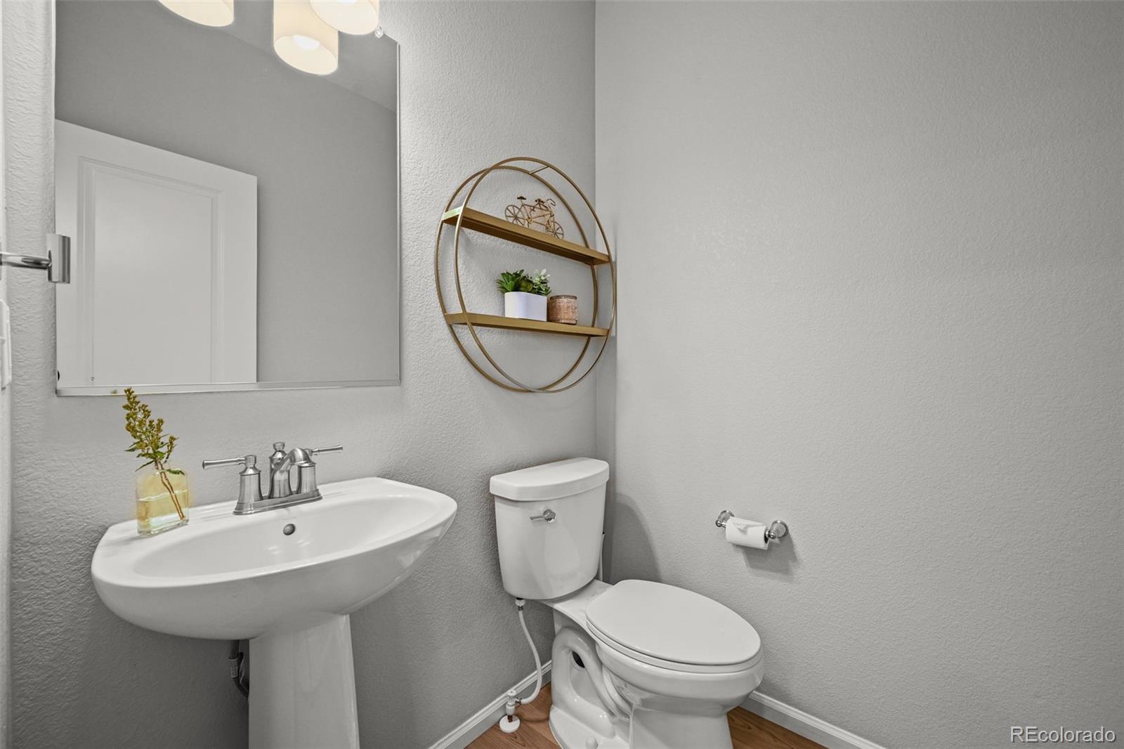 6374 North Fulton Street Denver, CO 80238 - Photo 16 of 49 a bathroom with a toilet sink and a mirror