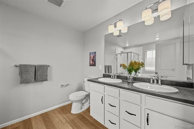 a bathroom with a granite countertop sink a toilet and a mirror