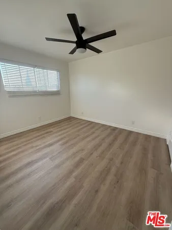 a view of a room with wooden floor and a window