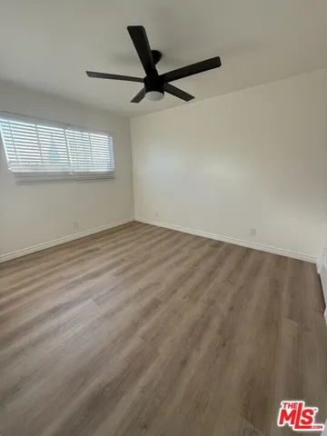 a view of a room with wooden floor and a window