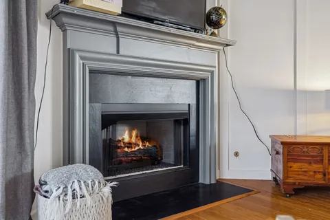 a living room with furniture fireplace and a large window