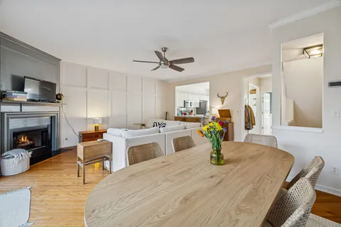 a kitchen with stainless steel appliances kitchen island granite countertop a table chairs and a refrigerator