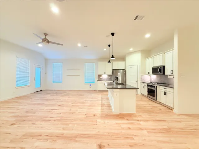 a large kitchen with kitchen island a sink stainless steel appliances and cabinets