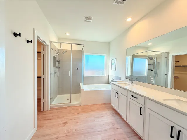 a bathroom with a granite countertop sink a mirror a bathtub and shower