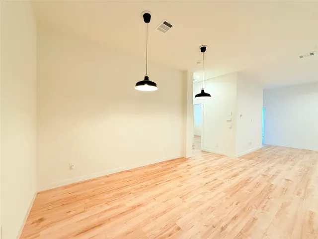 a view of empty room with a ceiling fan and a wooden floor