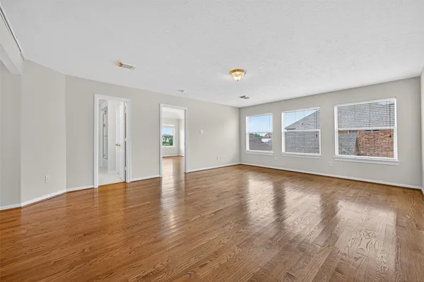 a view of an empty room with wooden floor