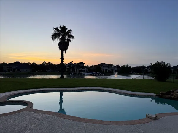 a view of a house with pool and a yard