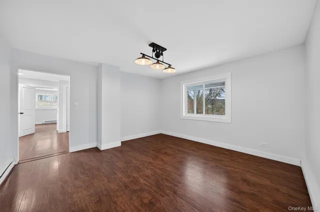 a view of a room with wooden floor and ceiling fan