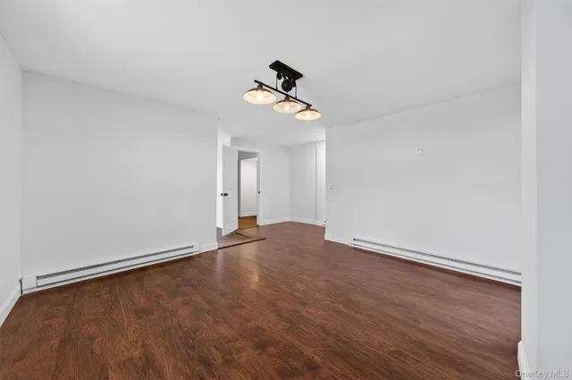 a view of empty room with wooden floor and ceiling fan