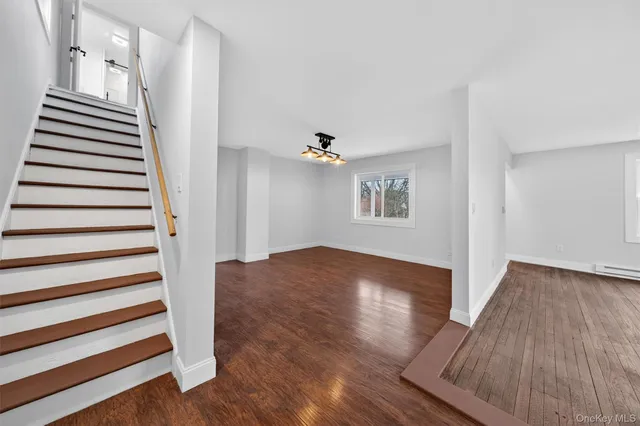 an empty room with wooden floor and white walls