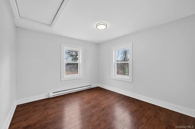 a view of a room with wooden floor and white walls
