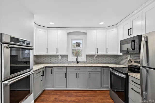 a kitchen with stainless steel appliances granite countertop a refrigerator stove and sink