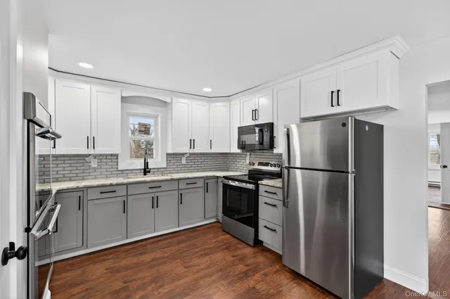 a kitchen with a refrigerator cabinets and wooden floor