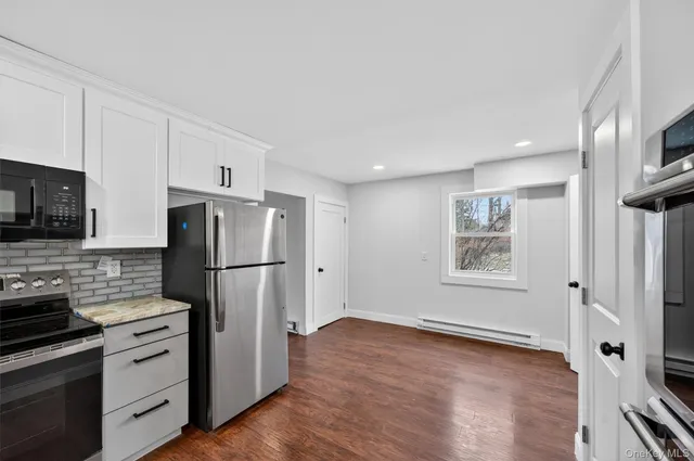 a view of an empty room with a fireplace and a window