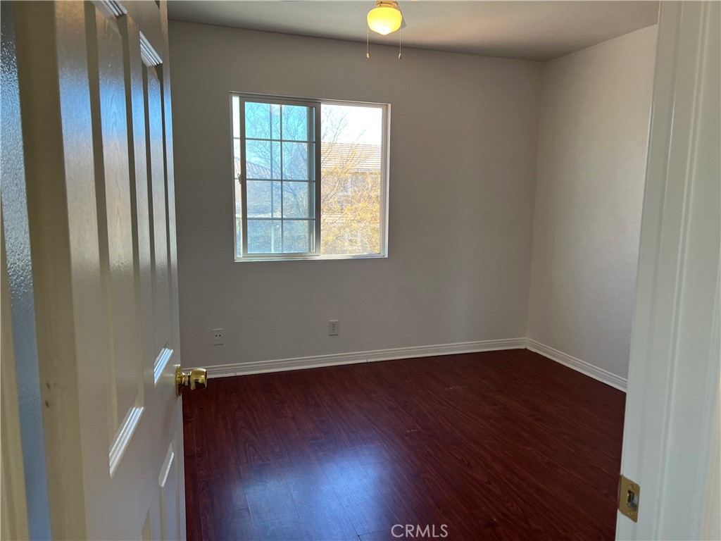 40305 Reata Road Palmdale, CA 93550 - Photo 12 of 20 an empty room with wooden floor and windows