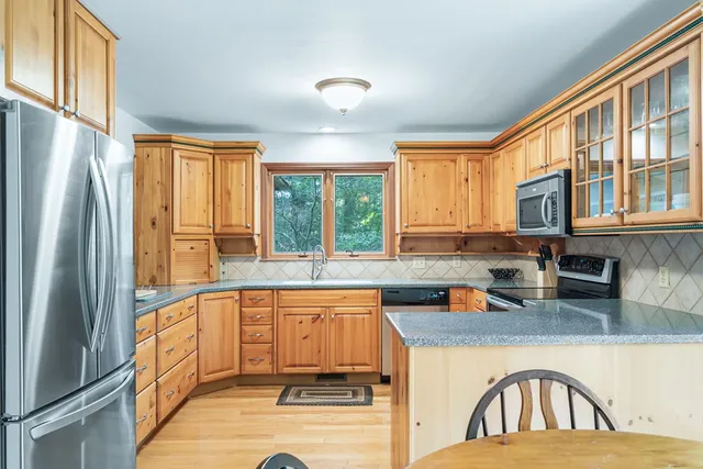 a kitchen with stainless steel appliances granite countertop a refrigerator a sink a stove and island