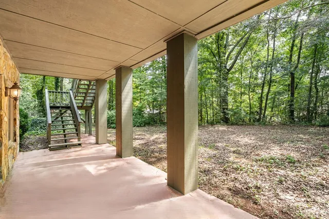 a view of a backyard with floor to ceiling window and tree