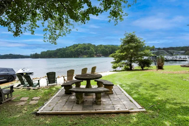 a view of a lake with table and chairs