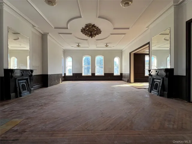 a view of a hall with wooden floor and furniture