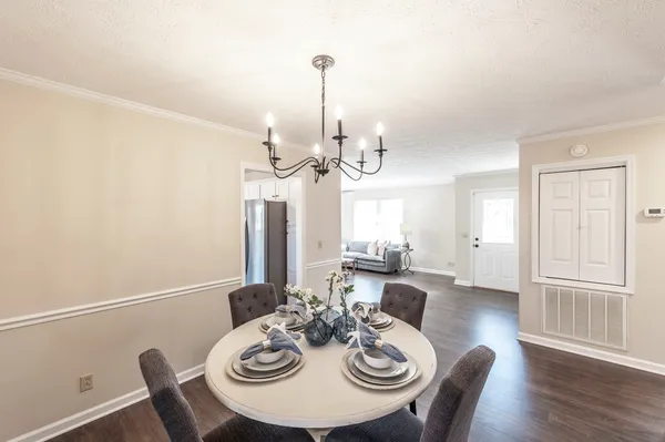 a view of a dining room with furniture a chandelier and wooden floor