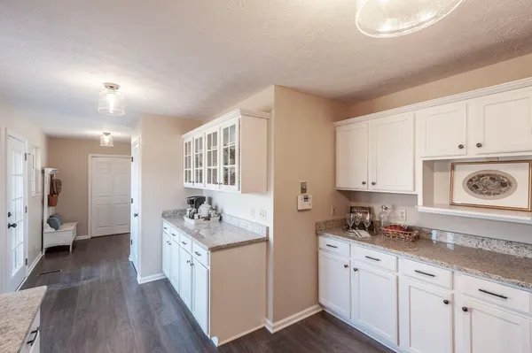 a kitchen with granite countertop a sink stove and cabinets