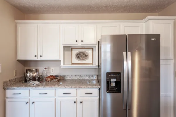 a kitchen with stainless steel appliances granite countertop a refrigerator and a stove