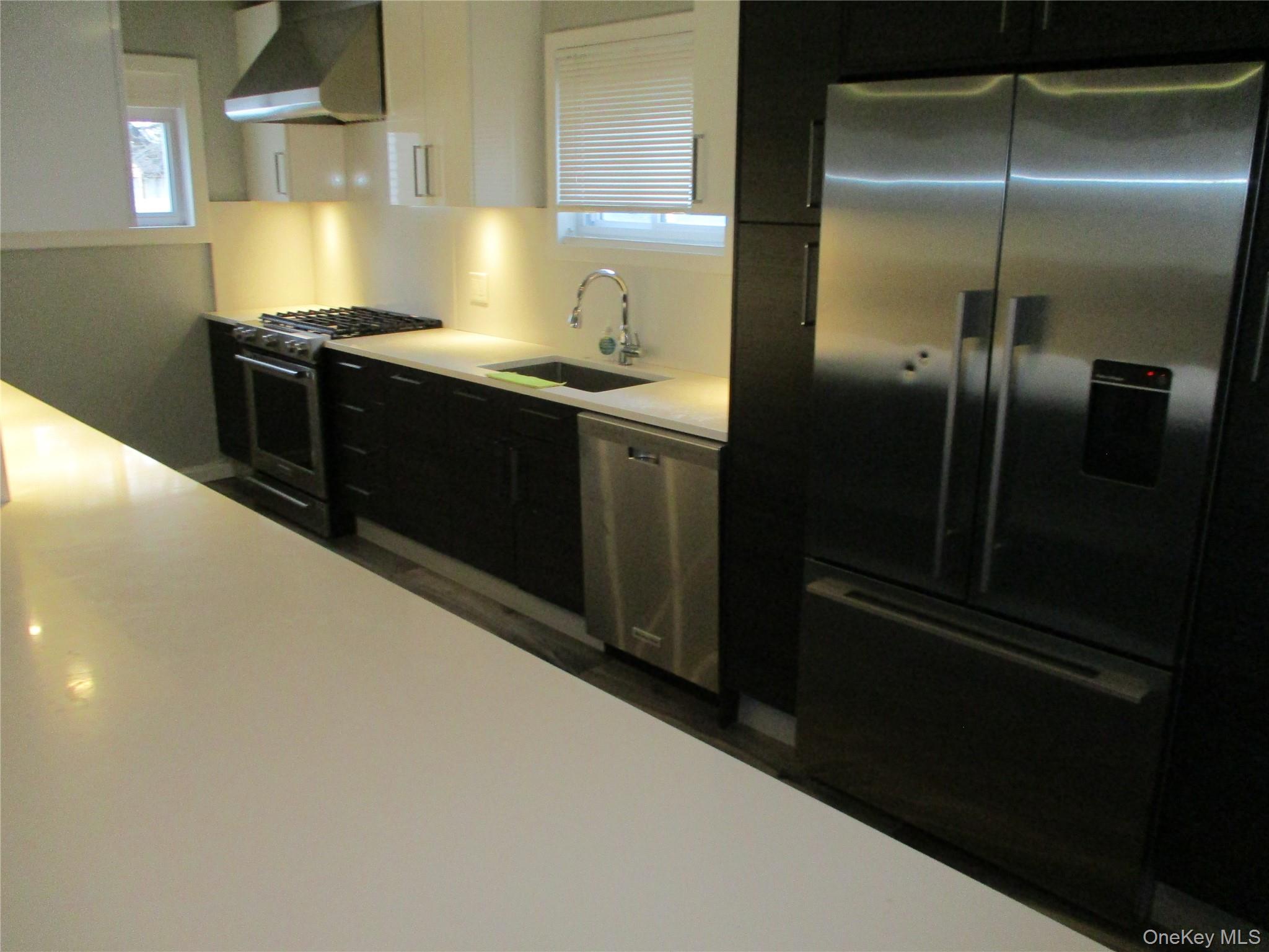 99 North Strathmore Street Valley Stream, NY 11581 - Photo 3 of 12 a kitchen with stainless steel appliances kitchen island granite countertop a refrigerator a sink and stove