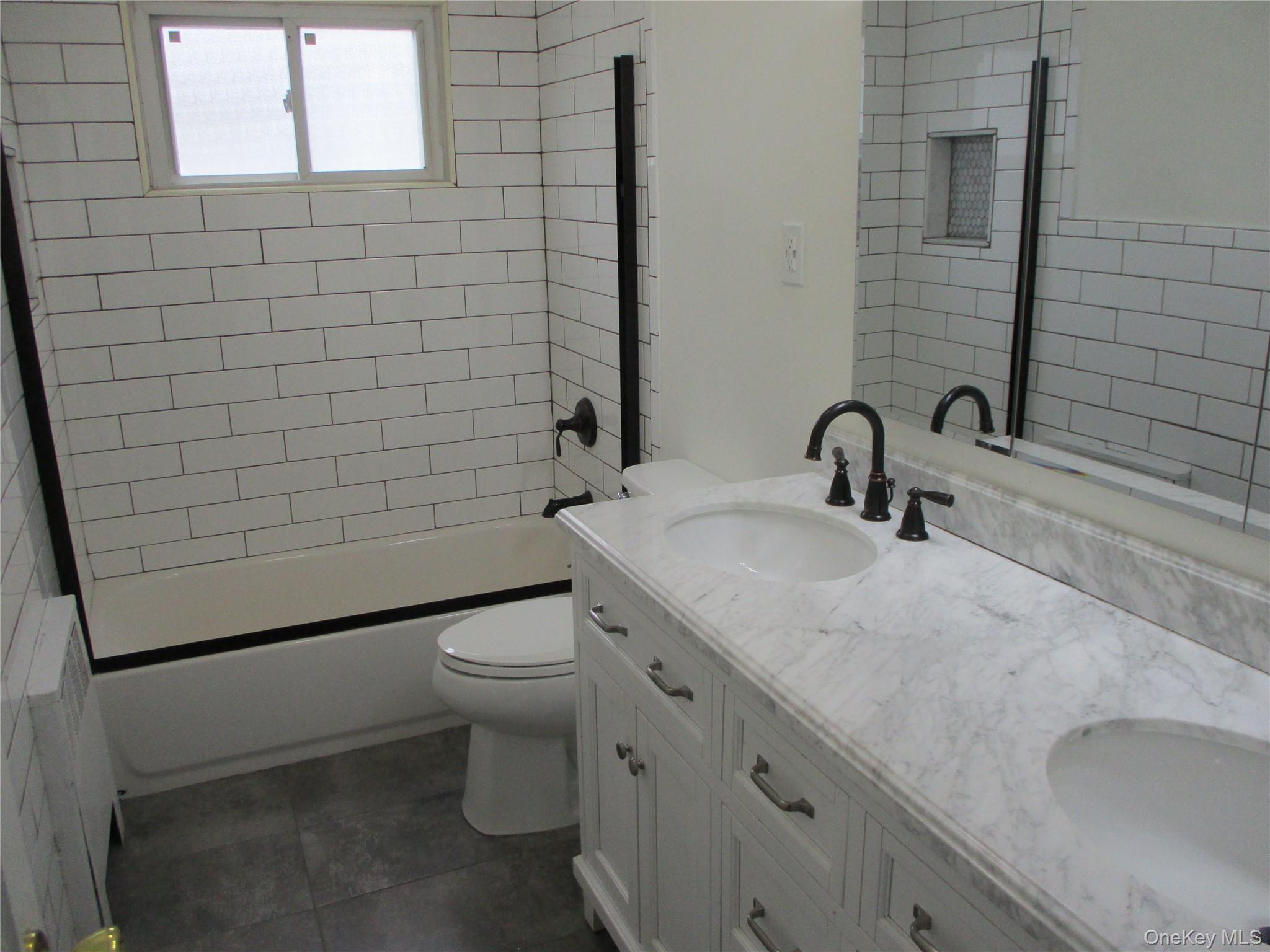 99 North Strathmore Street Valley Stream, NY 11581 - Photo 4 of 12 a bathroom with a sink a toilet and shower