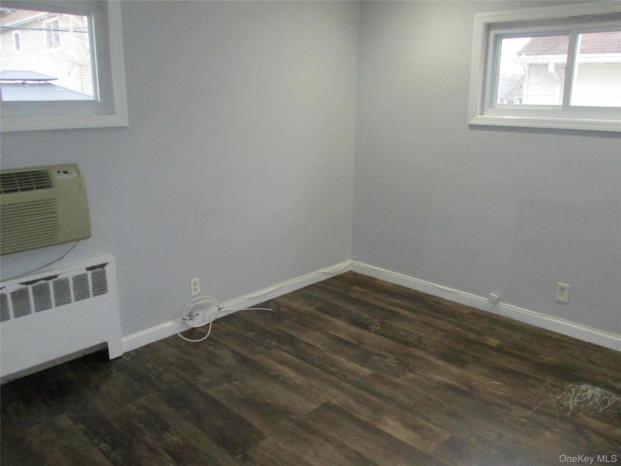 99 North Strathmore Street Valley Stream, NY 11581 - Photo 7 of 12 an empty room with wooden floor and windows