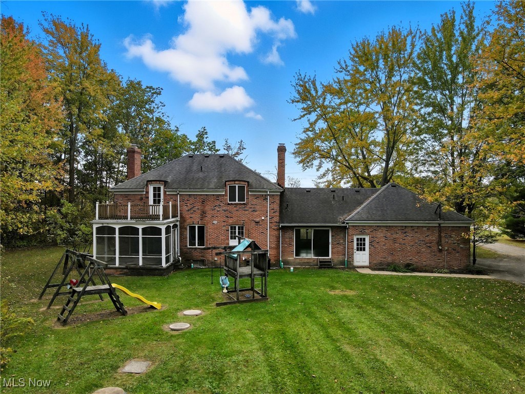 11710 Butternut Road Chardon, OH 44024 - Photo 46 of 48 Back of house with brick siding, a yard, and a sunroom