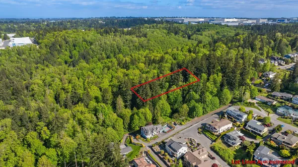 an aerial view of a residential houses with a yard and mountain view in back