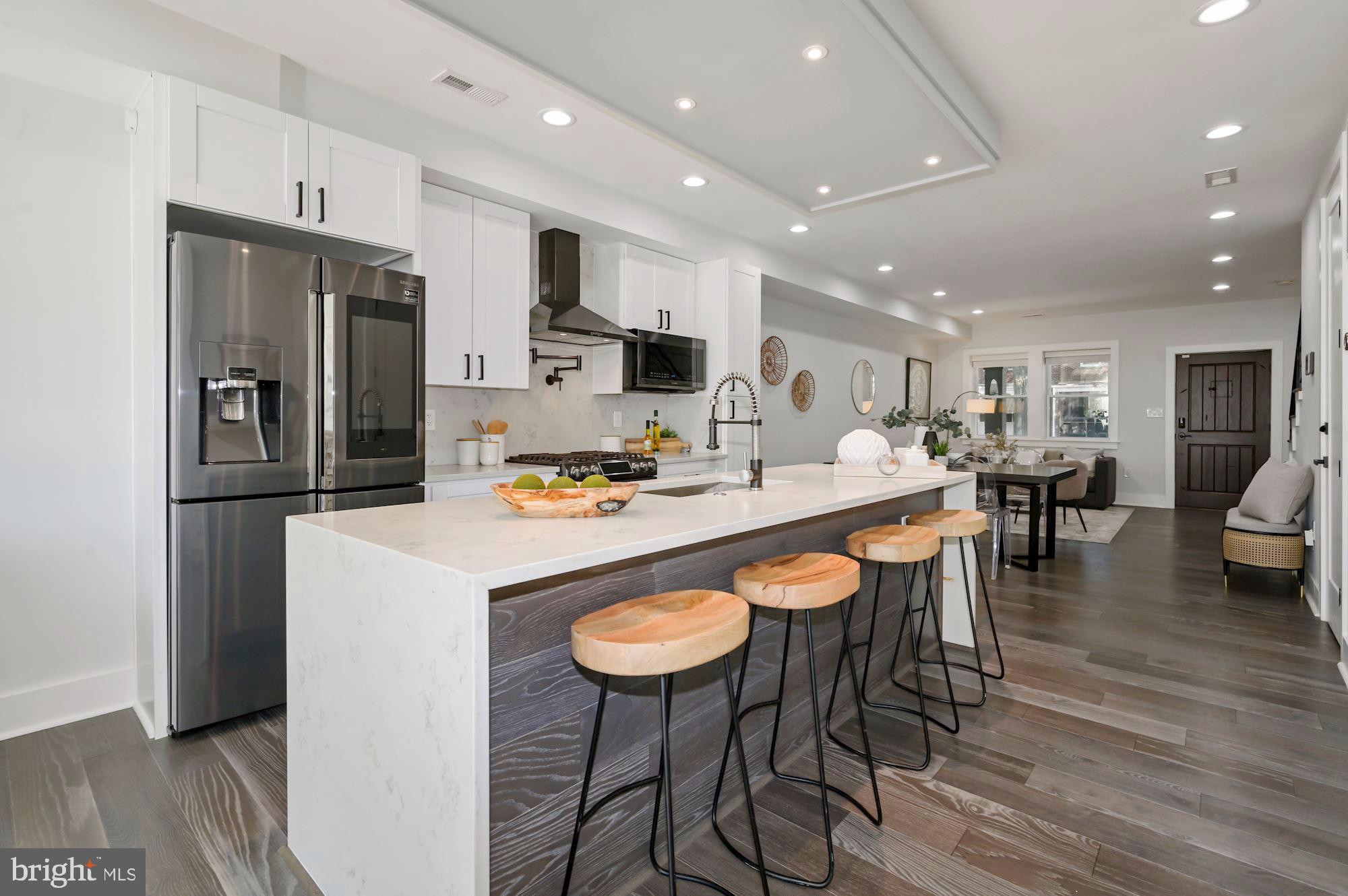 418 21st Street Northeast Washington, DC 20002 - Photo 10 of 48 a kitchen with stainless steel appliances granite countertop a table chairs refrigerator and microwave
