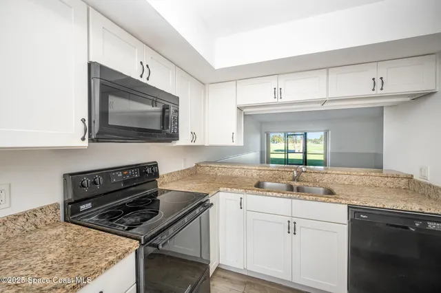 a kitchen with a sink stove and microwave