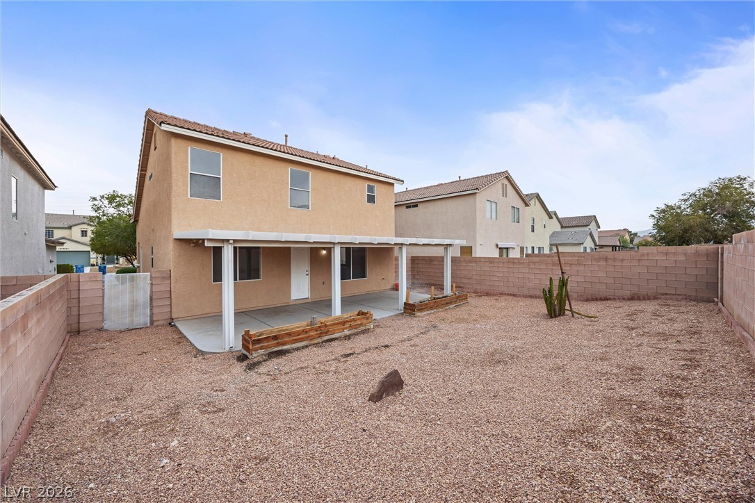 2650 Whisper Ridge Street Las Vegas, NV 89156 - Photo 27 of 28 An enclosed desert backyard features a covered concrete patio and block wall fencing.