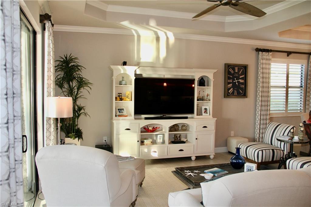 9449 Rialto Drive Naples, FL 34113 - Photo 14 of 44 a living room with furniture and a flat screen tv