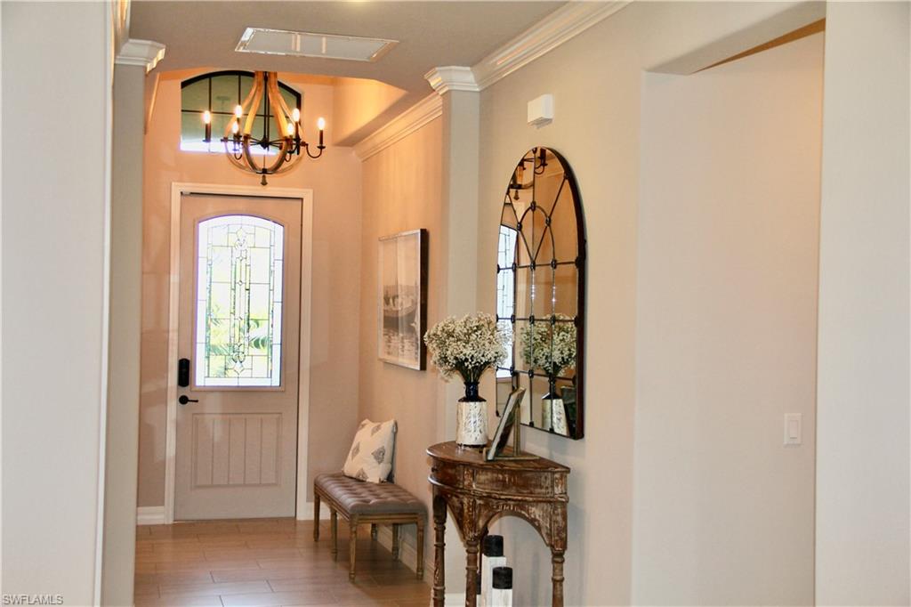9449 Rialto Drive Naples, FL 34113 - Photo 5 of 44 a view of a hallway with wooden floor and a dining room view