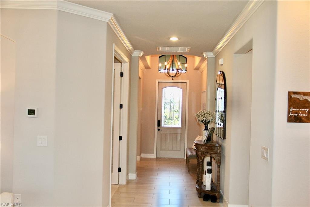 9449 Rialto Drive Naples, FL 34113 - Photo 7 of 44 a view of a hallway with wooden floor and windows